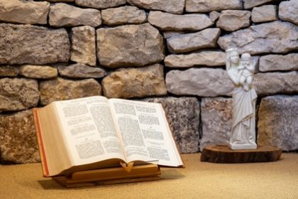 Bible ouverte et statue de la Vierge à l'enfant dans l'oratoire de la maison d'accueil